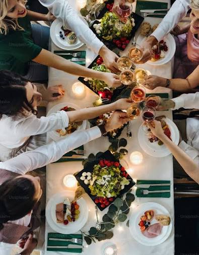 An office group toasting a comrade's birthday with a toast at a busy restaurant
