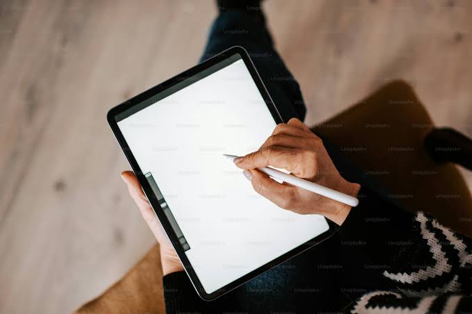 close-up of a person writing on a digital sketchpad